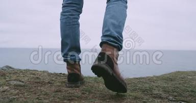 详情男子带着一双棕色靴子在山顶镜头前走到山的岸边